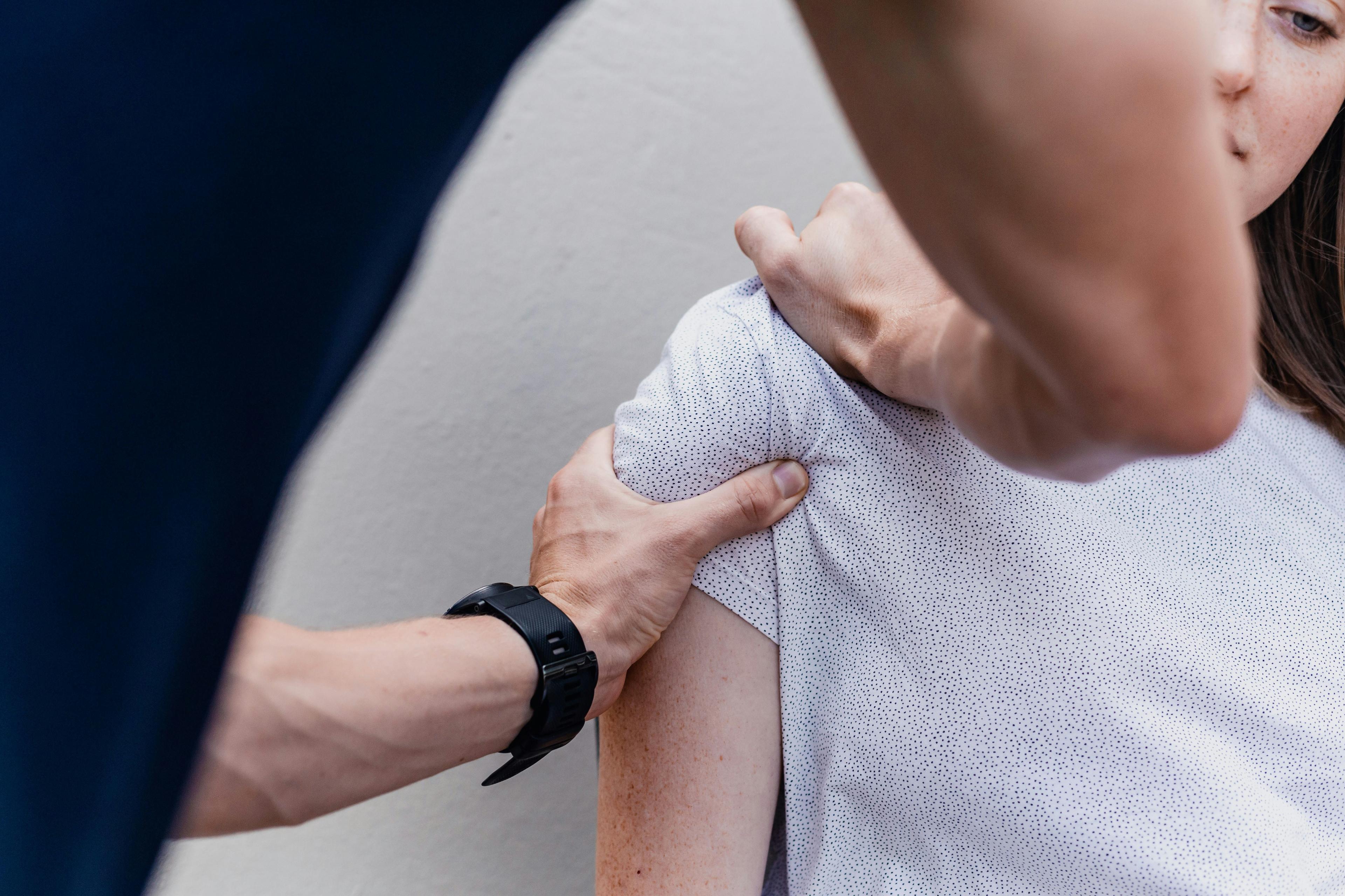 Athletic trainer performing a shoulder assessment on-site